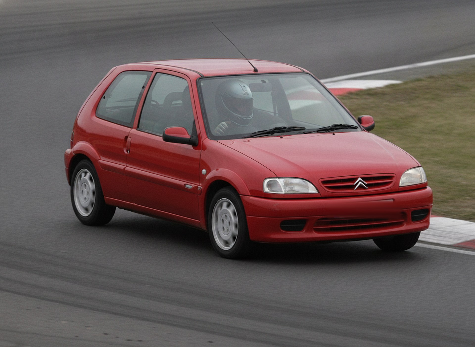 Red Citroen Saxo on a race circuit, driver in a plain black helmet, big brake kit guide