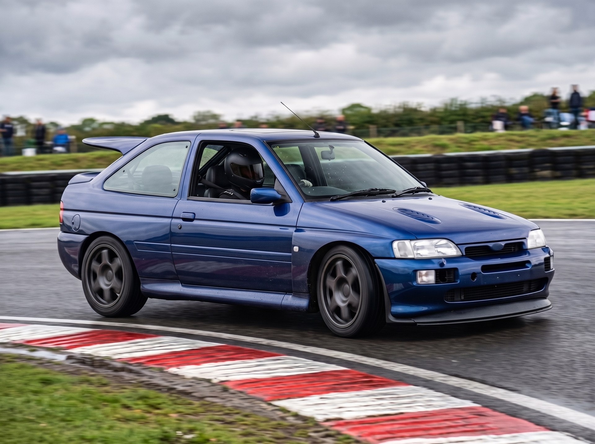 Blue Ford Escort RS Cosworth cornering on a British race circuit