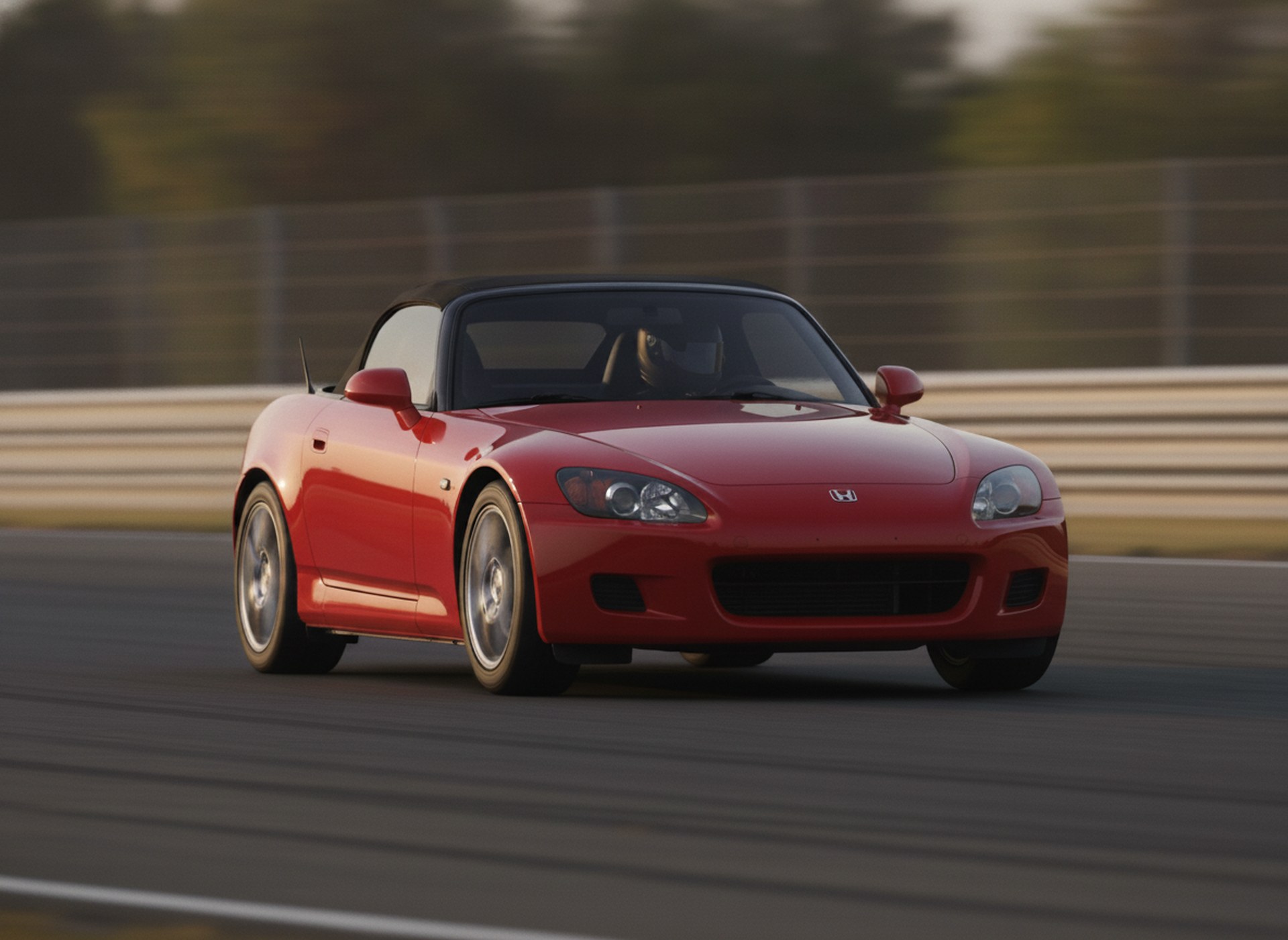 Red Honda S2000 roadster being driven hard through a corner on a race circuit