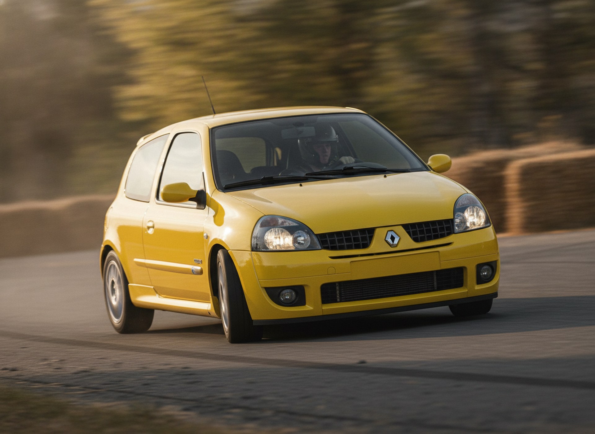Yellow Renault Clio MK2 driven hard through a corner on a rally stage, driver in a plain black helmet