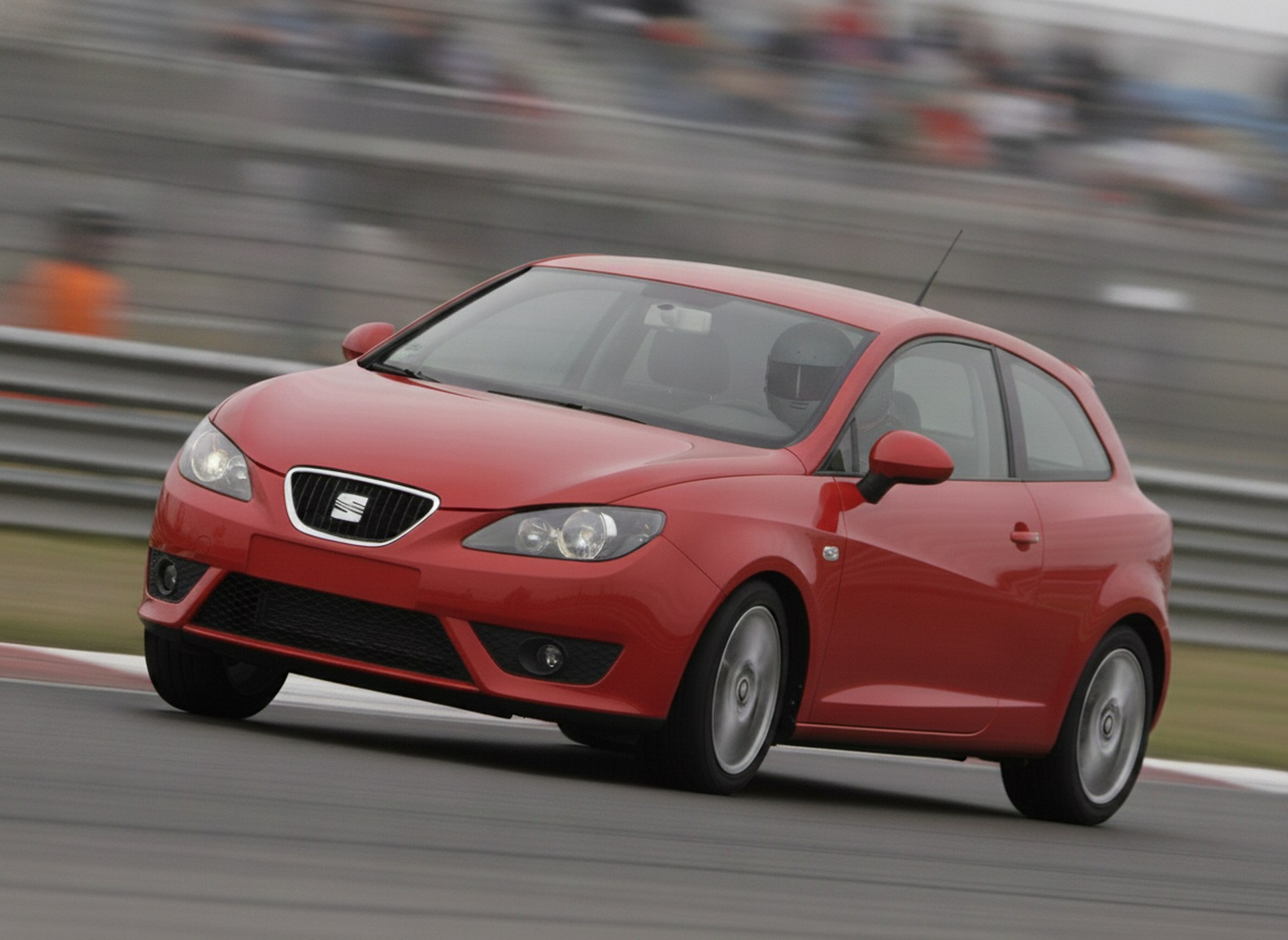 Red Seat Ibiza MK3 braking hard into a circuit corner, driver in a plain black helmet