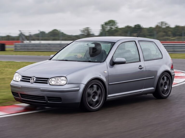 Silver Volkswagen Golf Mk4 cornering on a British race circuit