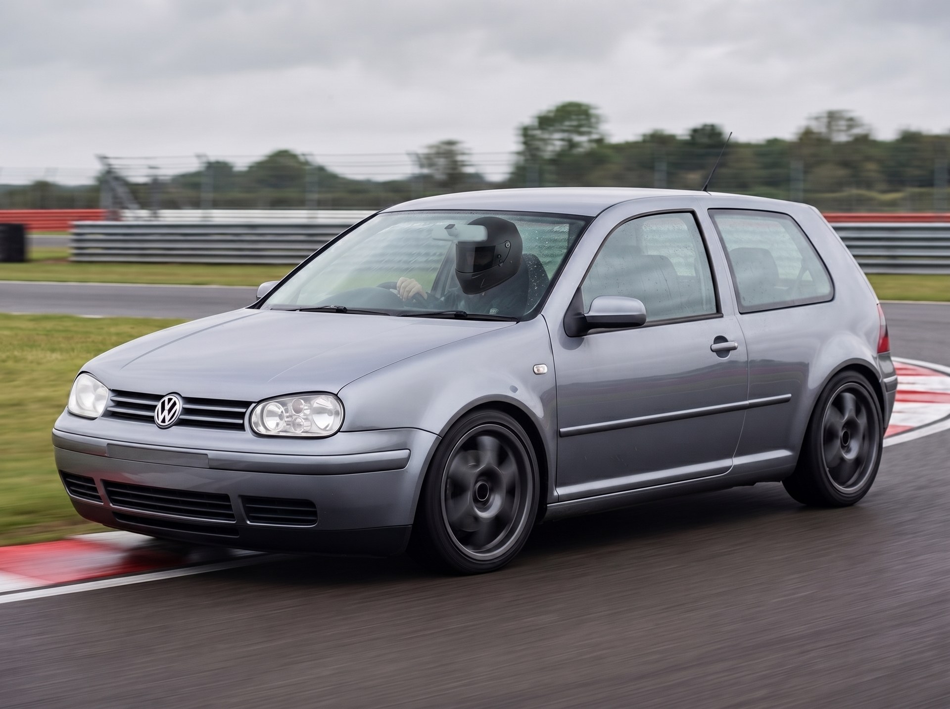 Silver Volkswagen Golf Mk4 cornering on a British race circuit