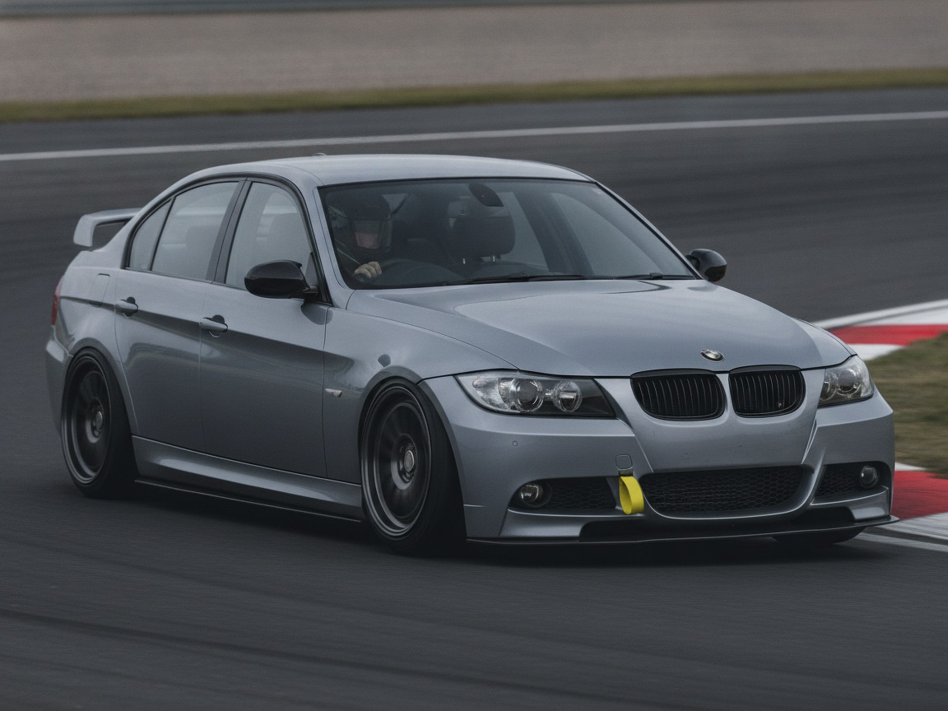 BMW 3-Series E90 saloon driving on a racing circuit