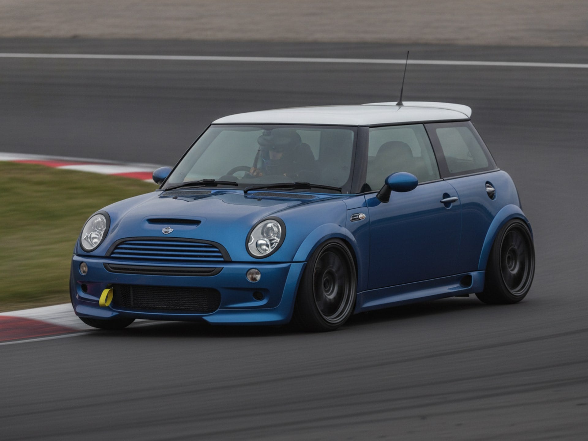 Green BMW Mini Cooper S R53 being driven hard through a corner on a tarmac stage