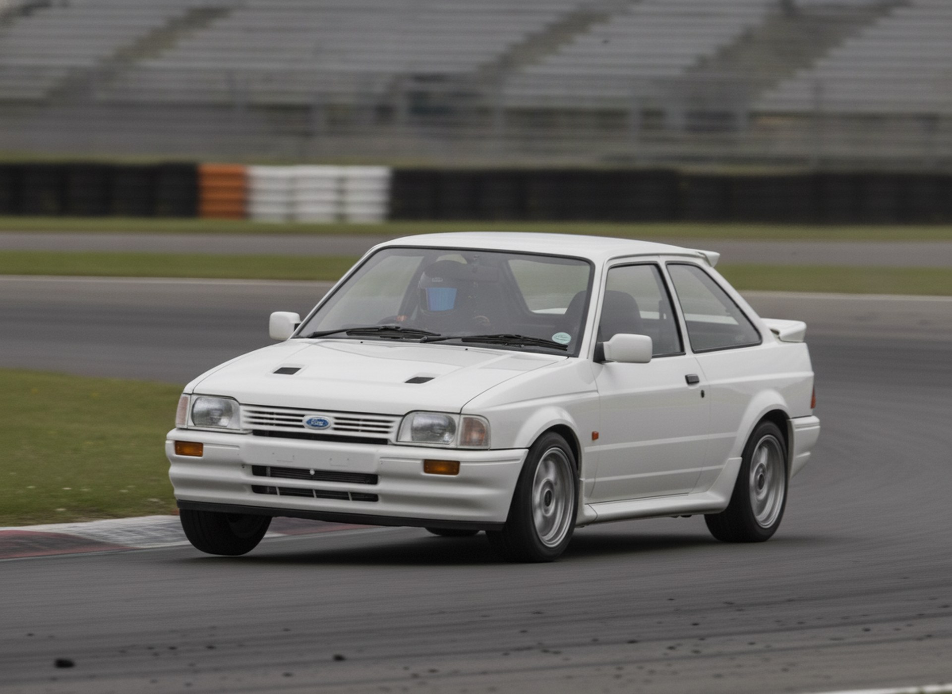 Ford Escort MK3 XR3i being driven hard through a circuit corner, driver in a plain matte black racing helmet