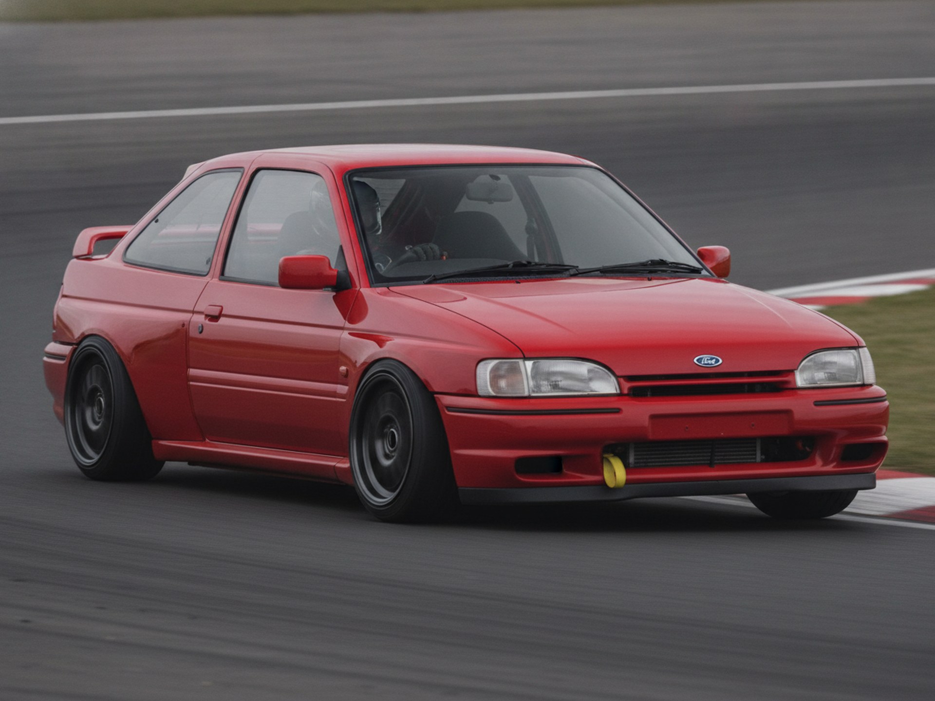 Blue Ford Escort RS Cosworth cornering on a British race circuit