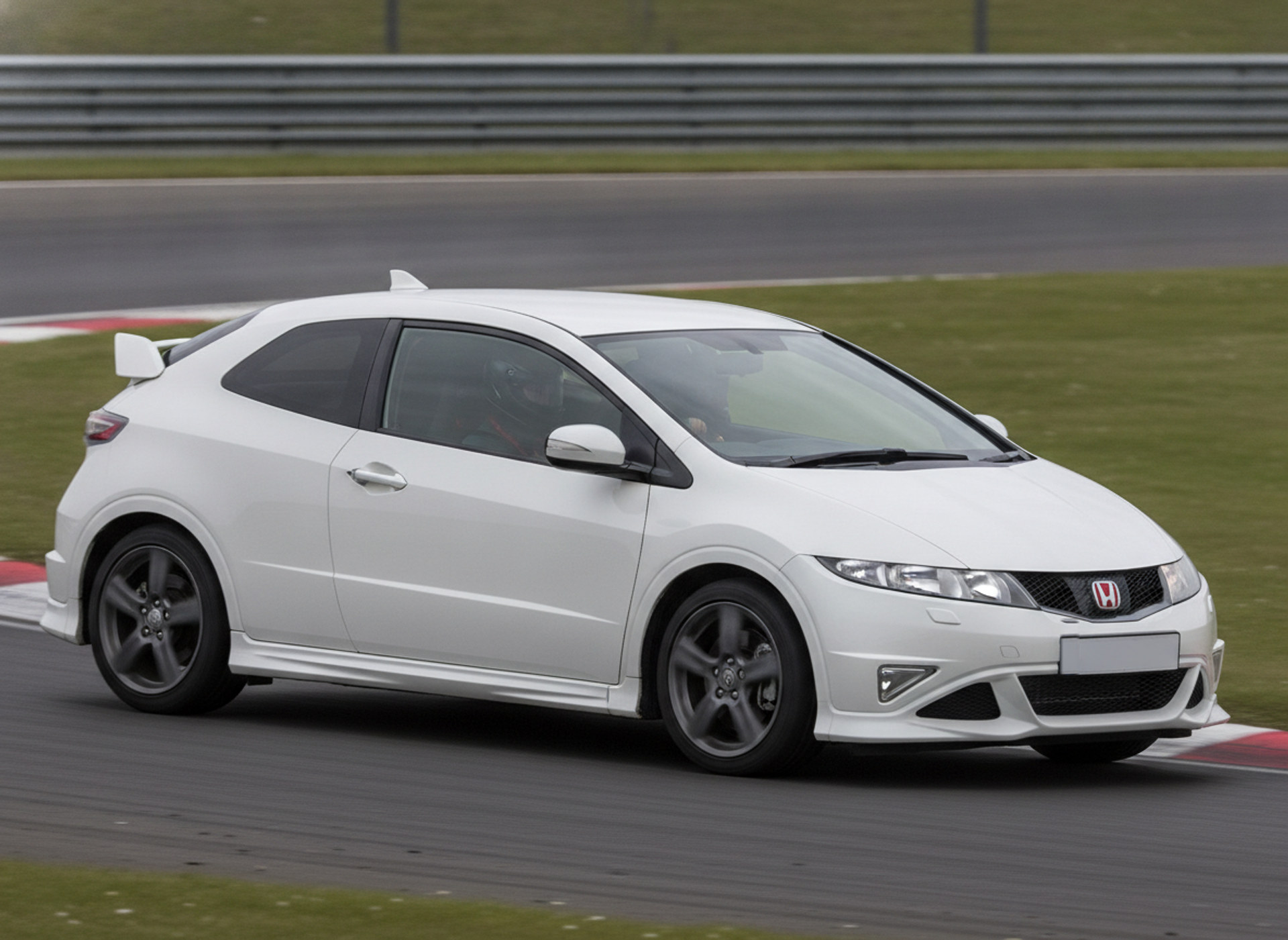 A white Honda Civic Type R FN2 cornering on a British race circuit