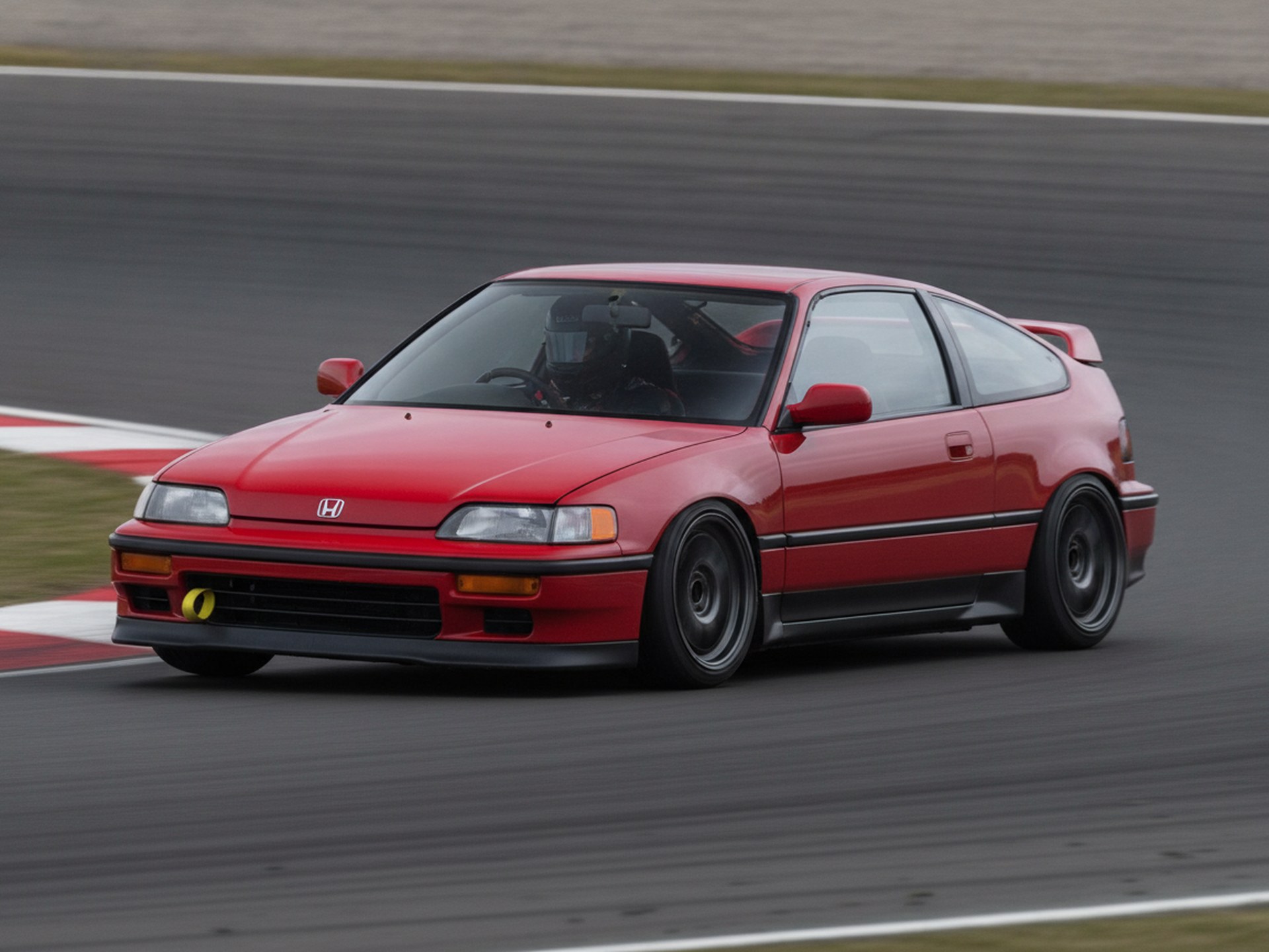 Red Honda CRX being driven hard through a corner on a race circuit