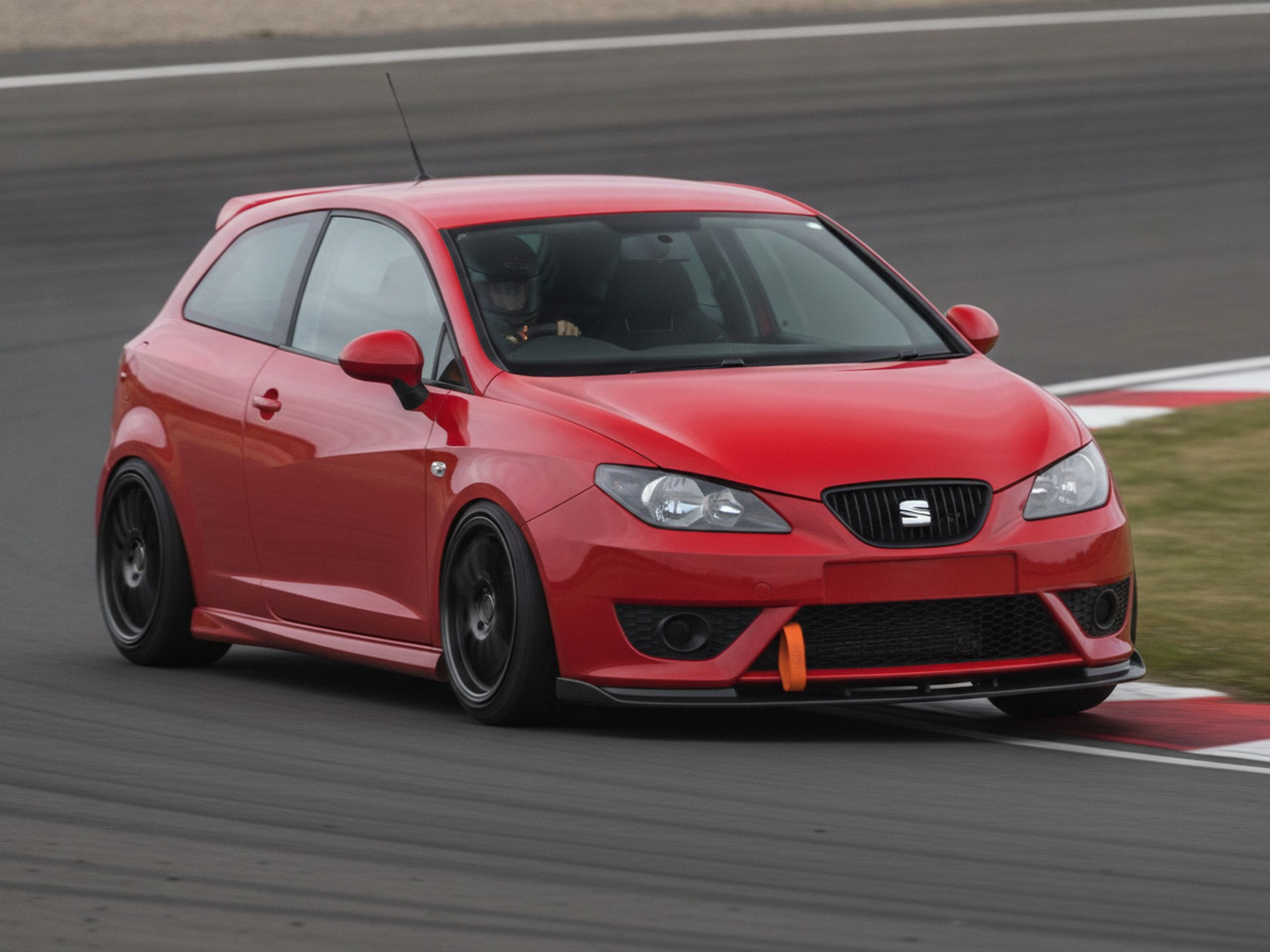 Red Seat Ibiza MK3 braking hard into a circuit corner, driver in a plain black helmet